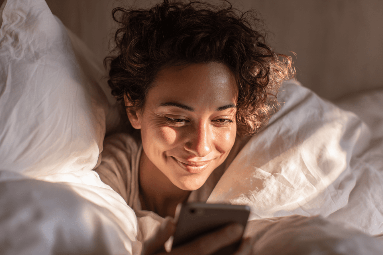 AI-generated illustrative image: A young woman reading a meaningful message on her phone in the soft morning light