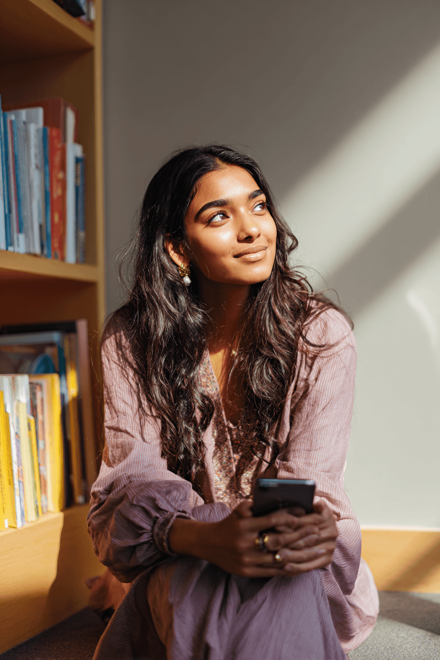 AI-generated illustrative image: A young woman looking up from her phone with a dreamy, grateful smile